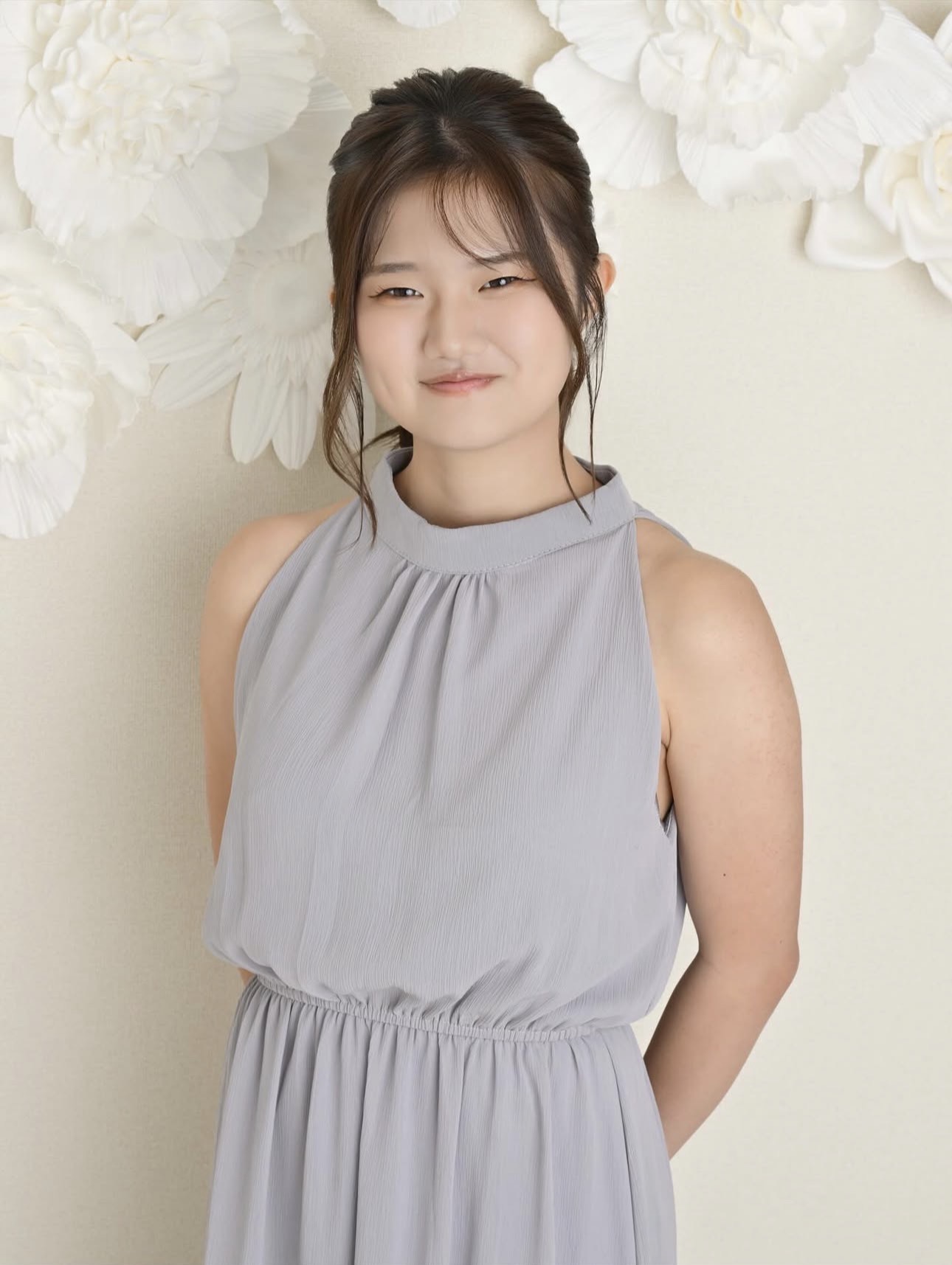 白い花を背景にした自然な笑顔のプロフィール写真