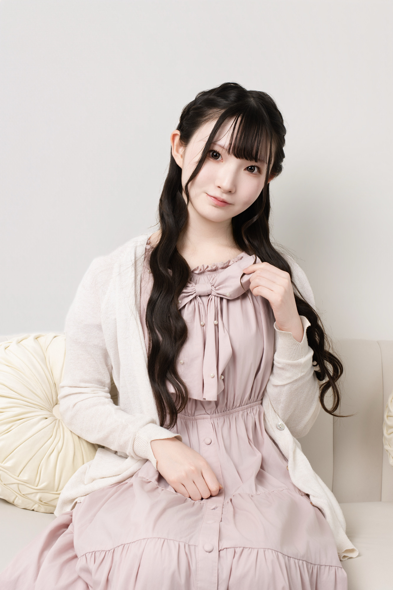 ピンクの私服でやさしく正面を見るプロフィール写真