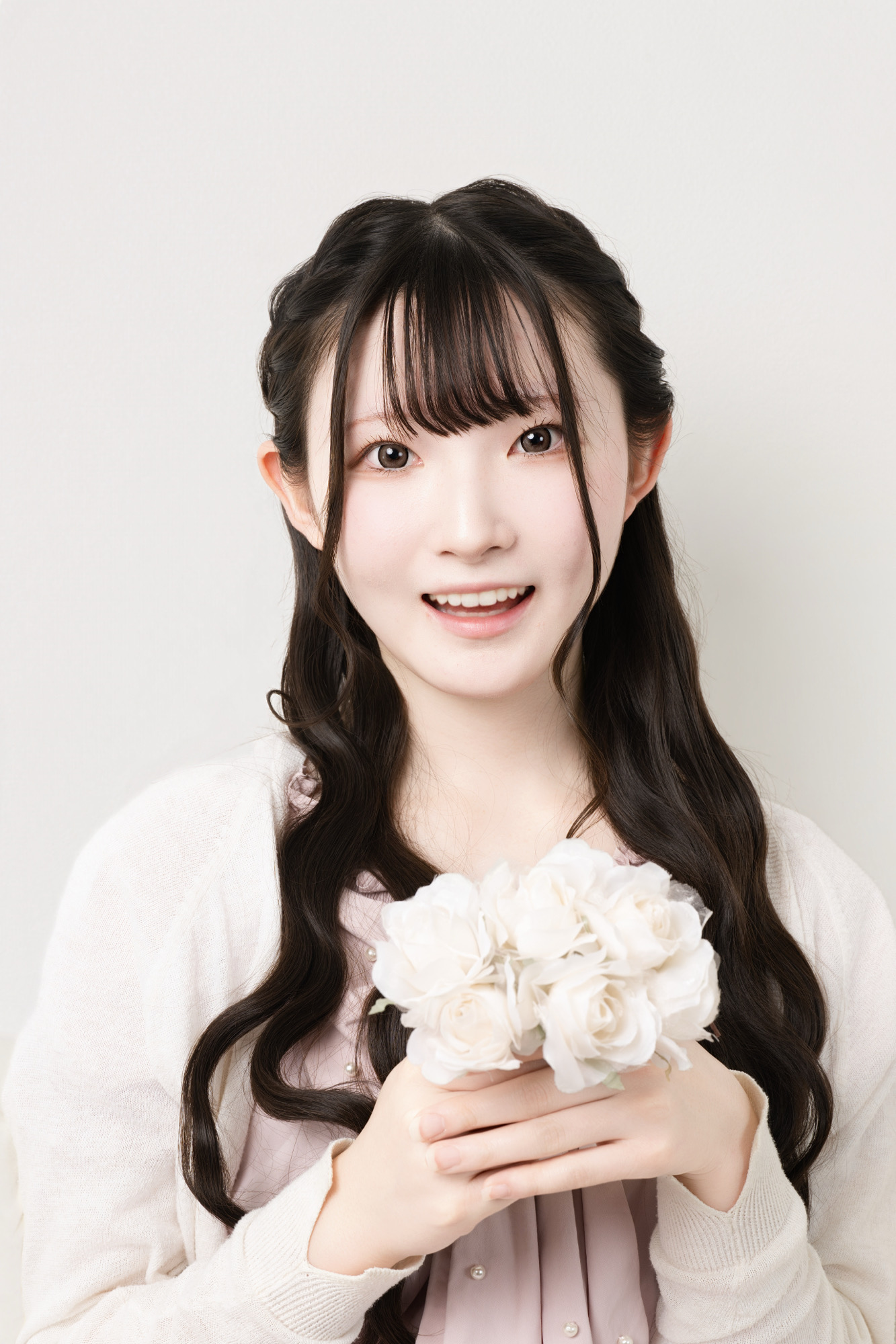 ピンクの私服で花を持ち明るく笑うプロフィール写真