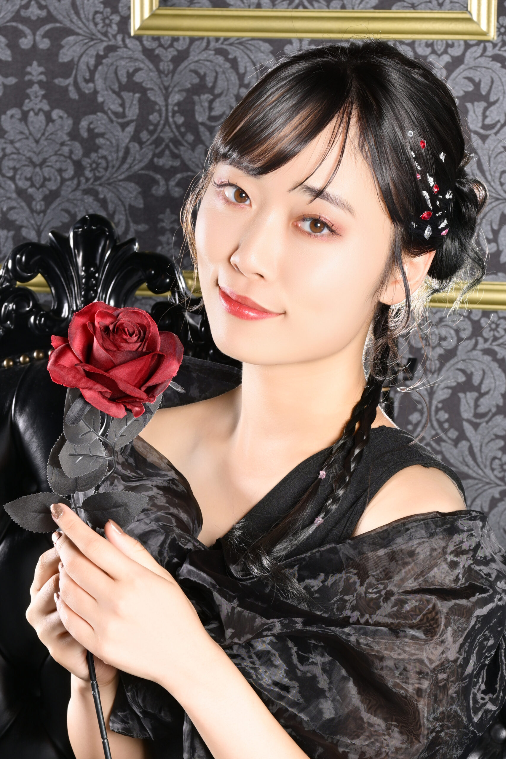 赤いバラを持った黒ドレスの寄りの宣材写真