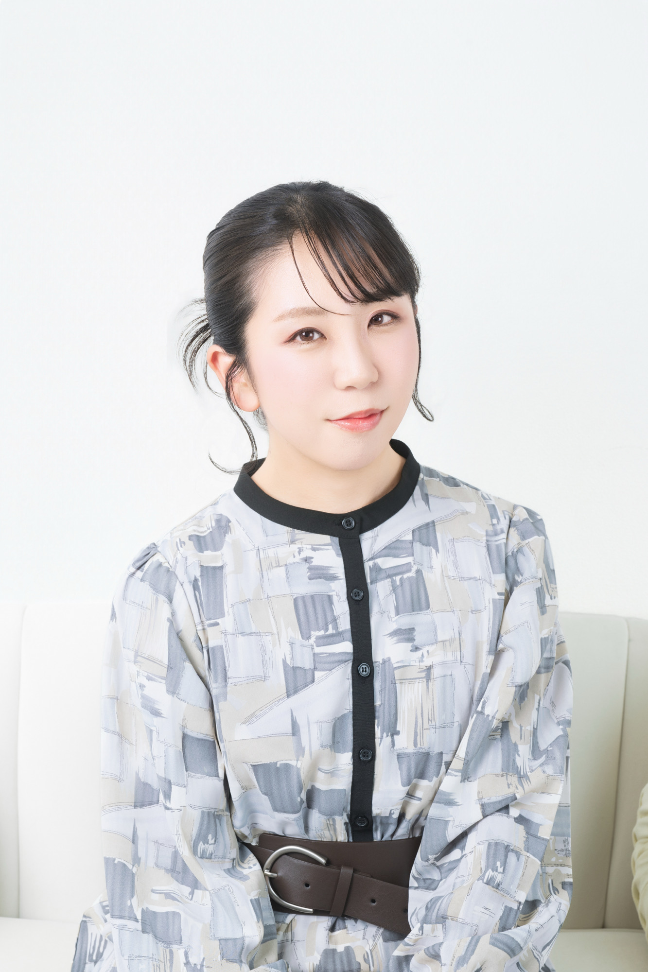 白背景とモノトーンの衣装で撮影した上品なプロフィール写真