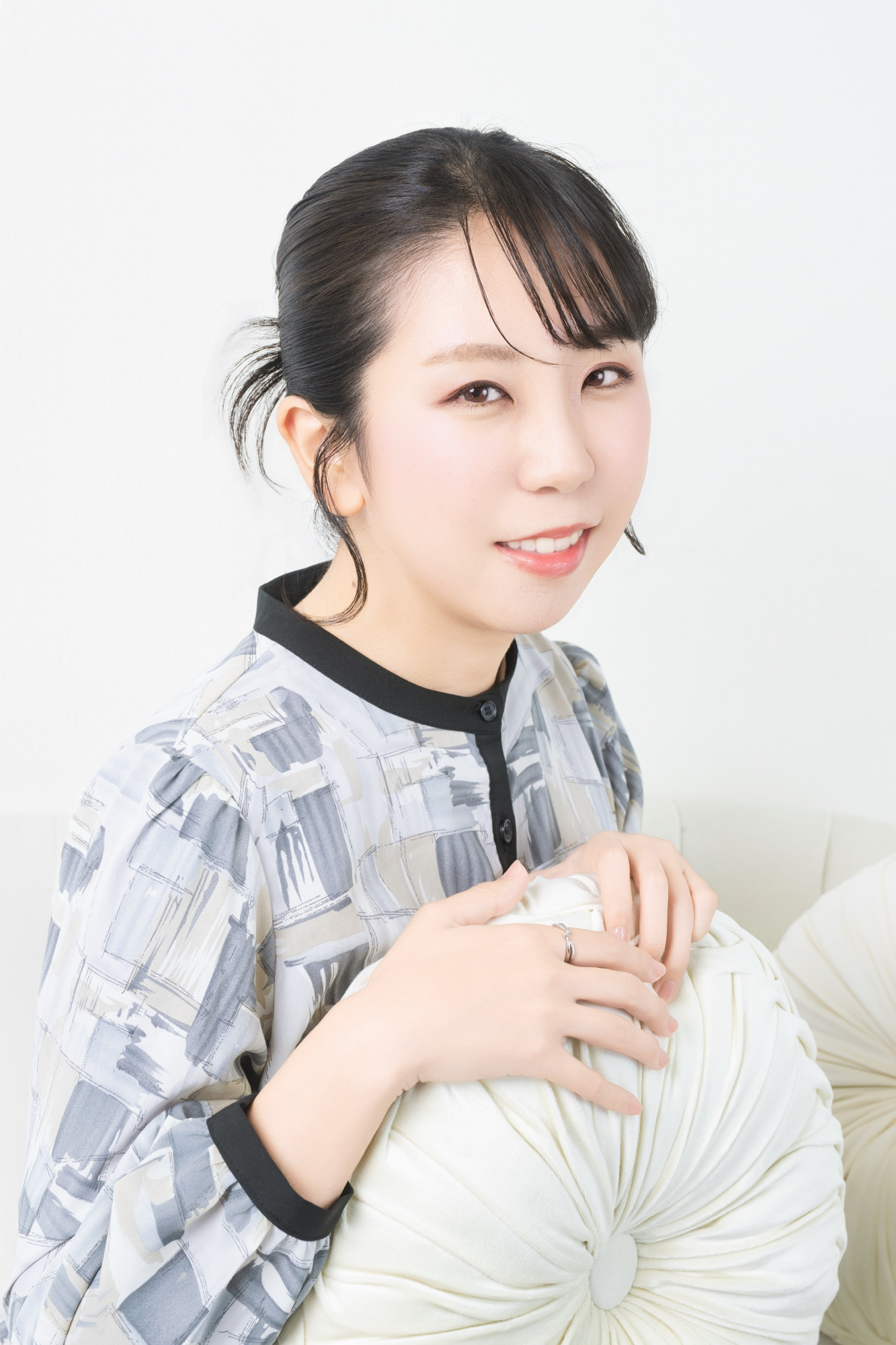 白背景で自然な笑顔を見せるプロフィール写真