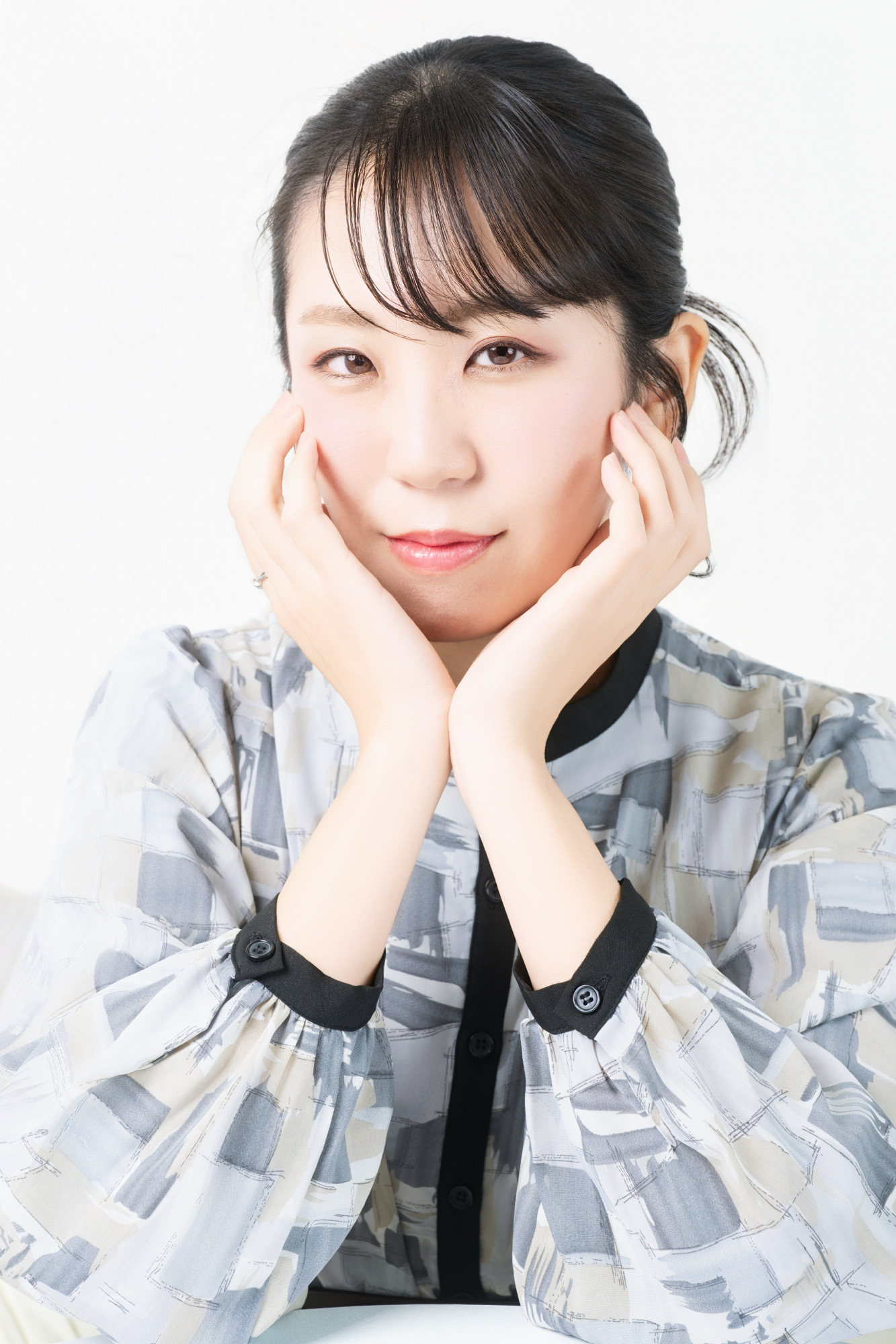 白背景で両手を頬に添えた親しみやすいプロフィール写真