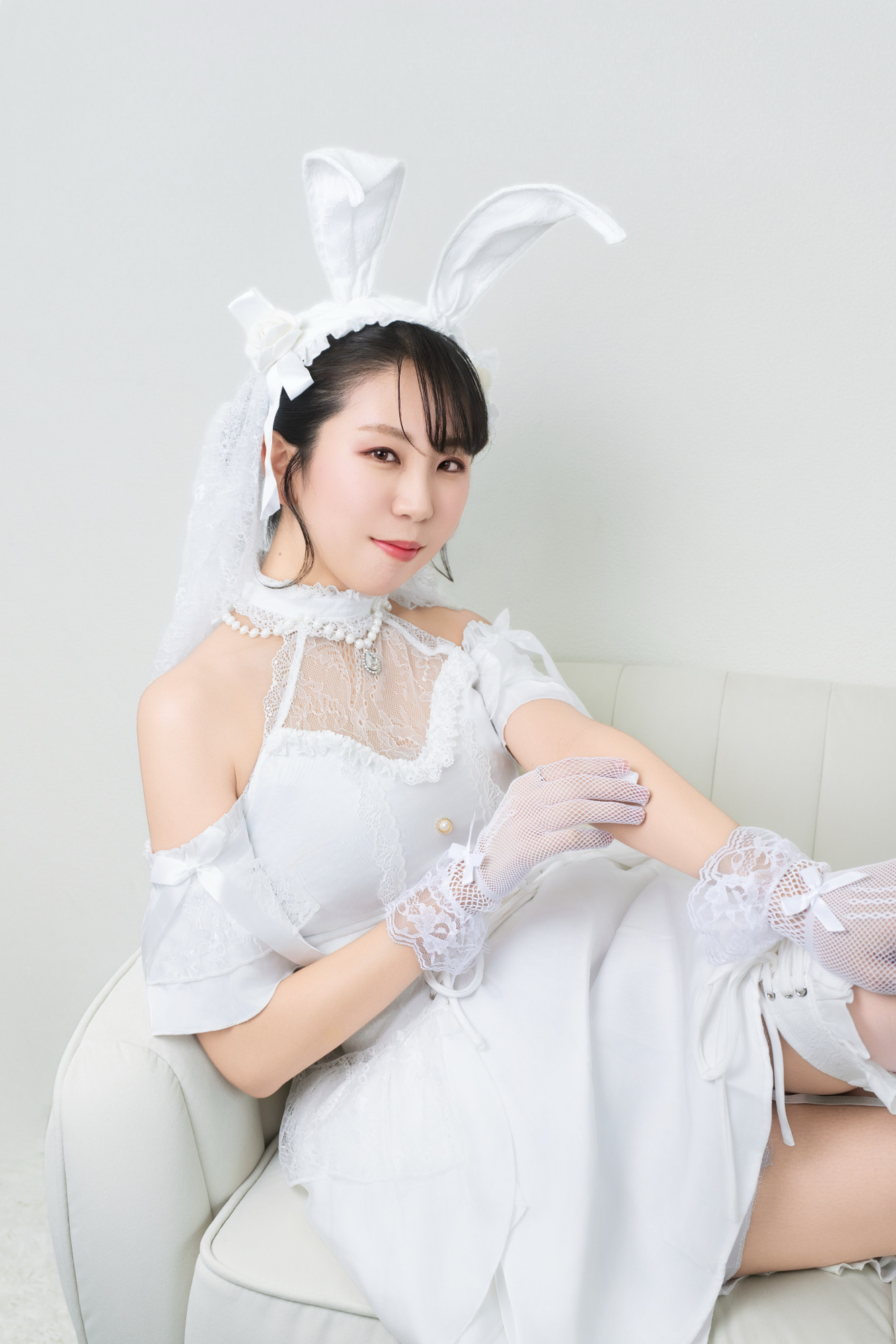 白いソファに座ったホワイトバニーの全身寄り宣材写真