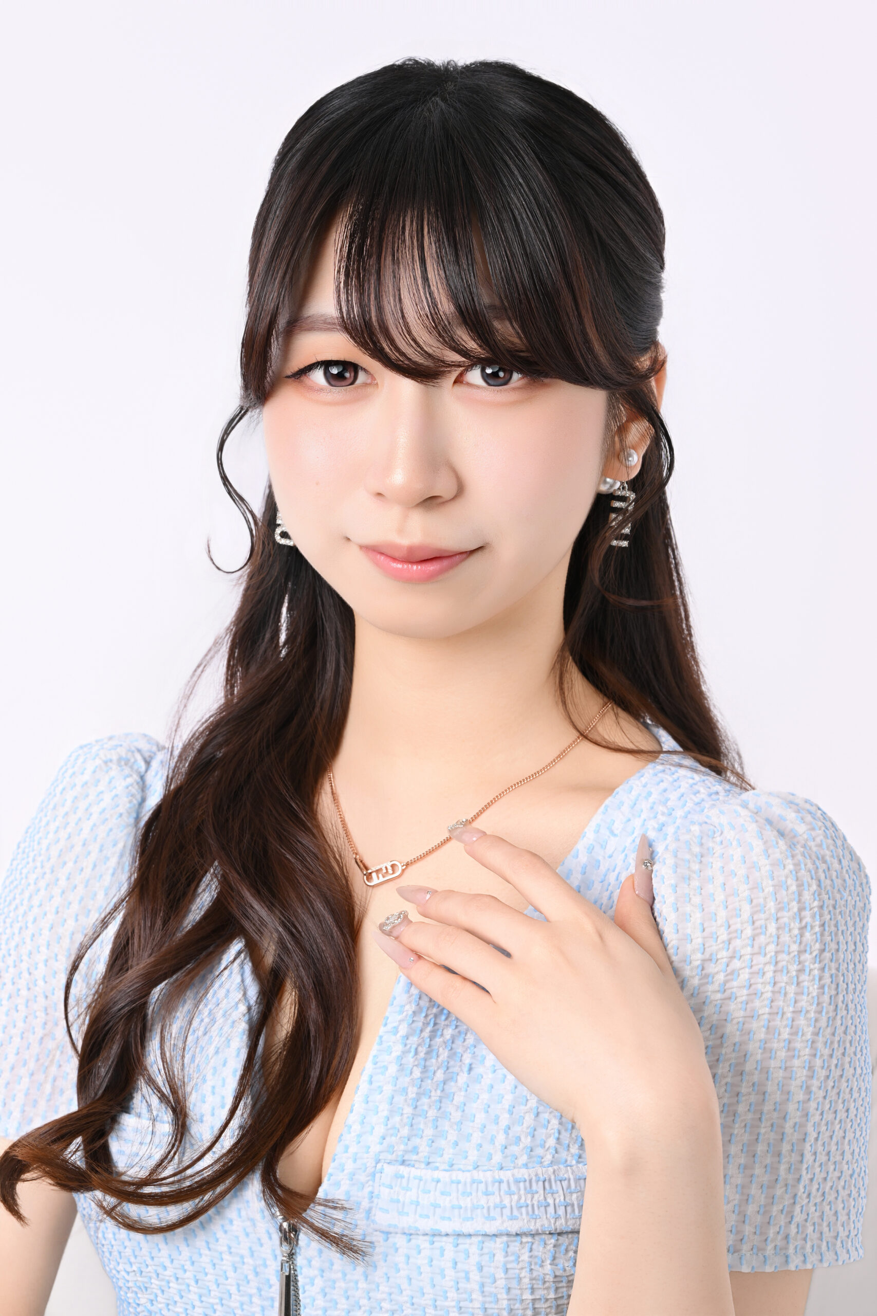 胸元に手を添えて微笑むブルー衣装の宣材写真